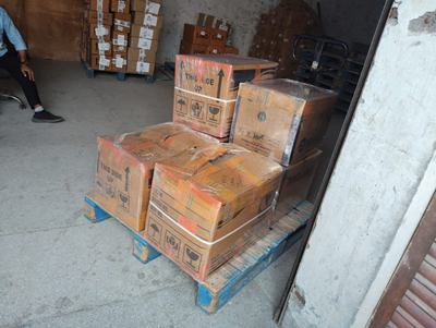 Strapped cartons on a trolley being moved through a doorway.