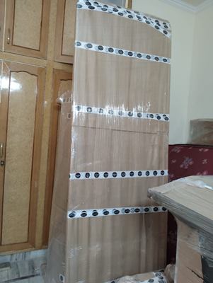 A wrapped panel with reinforced edging taped along its length, standing in a room.