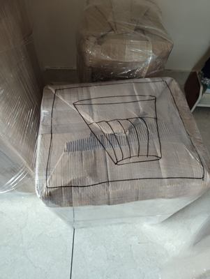 A wrapped table with a separately wrapped round top resting on it.