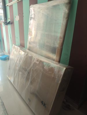A large flat panel wrapped in corrugated sheet, standing on edge against a wall.